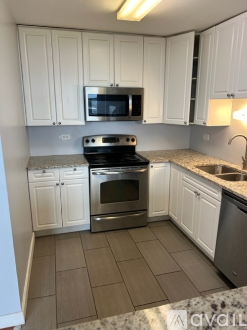 A kitchen with white cabinets and a granite countertop.