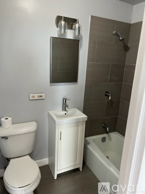 A white toilet sits next to a white cabinet in a bathroom.