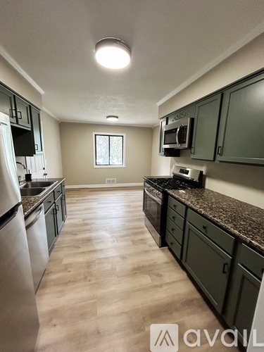 A kitchen with wooden floors and granite countertops.