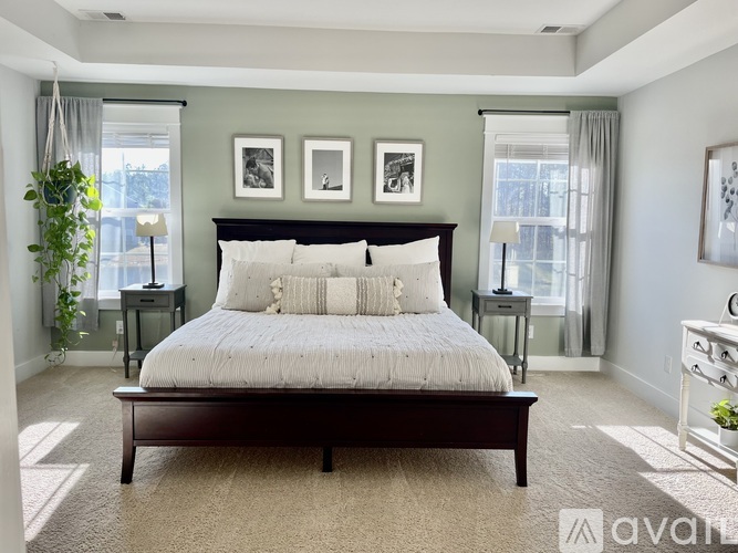A bedroom with a large bed and two nightstands.