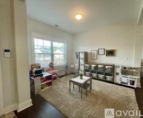 A living room with a table and chairs, a window, and a shelf with various items.