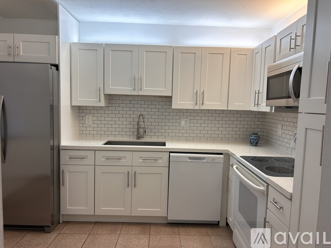 A kitchen with white cabinets and appliances.