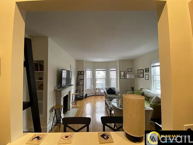 A living room with a fireplace and a dining table.