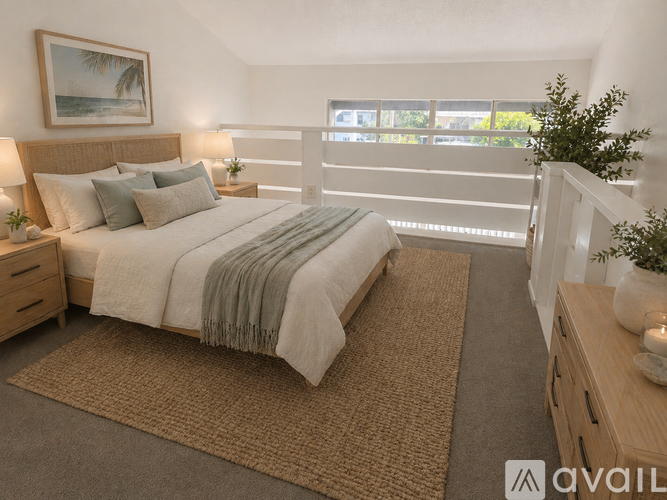 A bedroom with a large bed and a balcony overlooking the ocean.