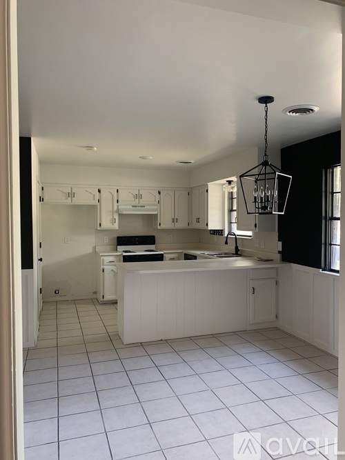 A kitchen with white cabinets and a white island.