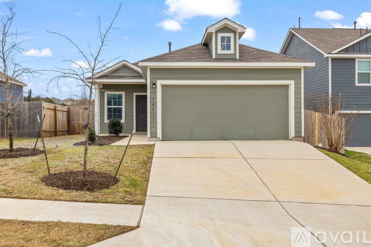 A house with a grey garage door and a brown roof.