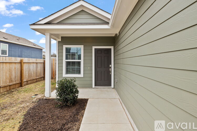 A house with a grey front siding and a brown door.