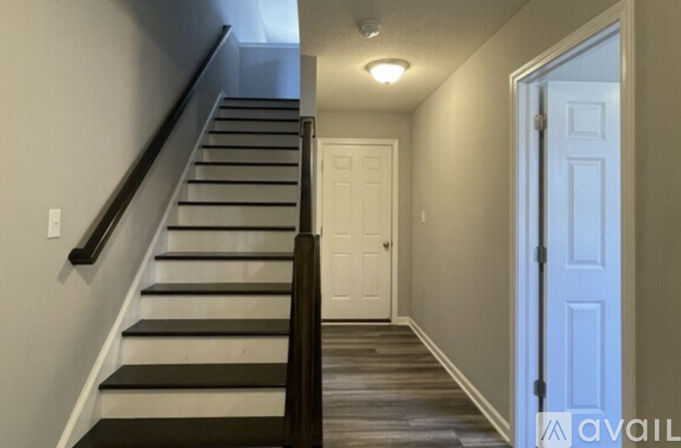 A hallway with a staircase leading to the second floor.