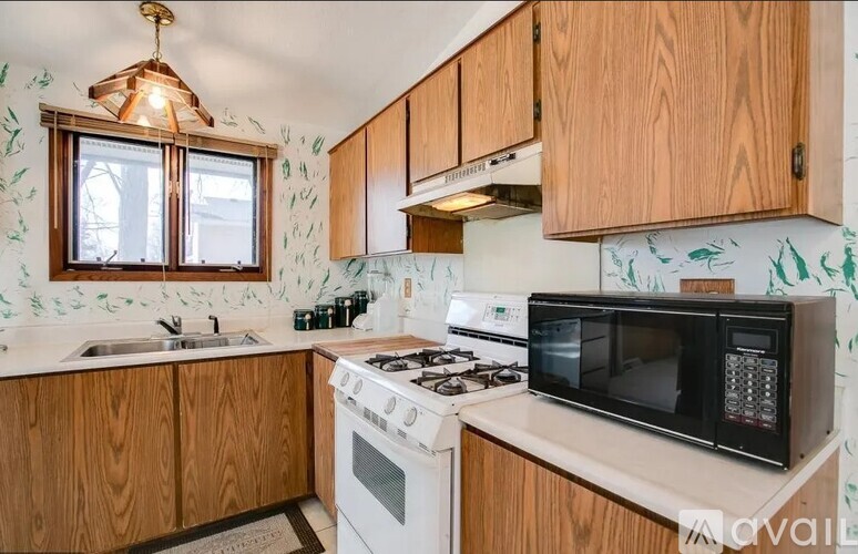A kitchen with wooden cabinets and a white stove top oven.
