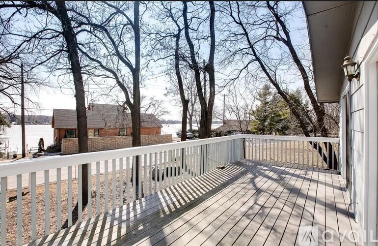 A deck with a white railing and wooden floor.