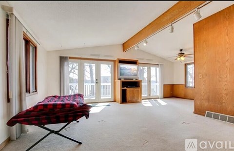 A living room with a red and black plaid chair in the foreground.