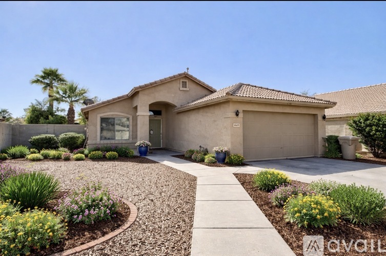 A house with a driveway and landscaping in front.