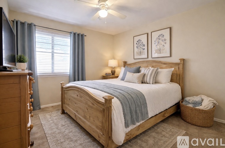A bedroom with a large bed and a ceiling fan.