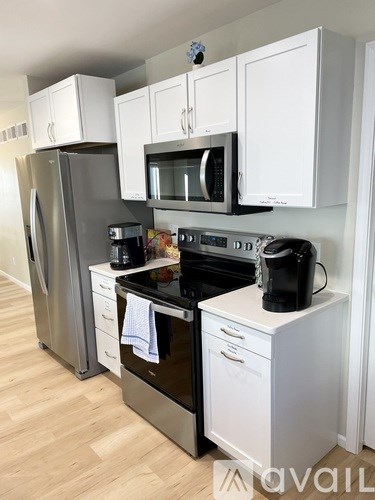 A kitchen with white cabinets and appliances.