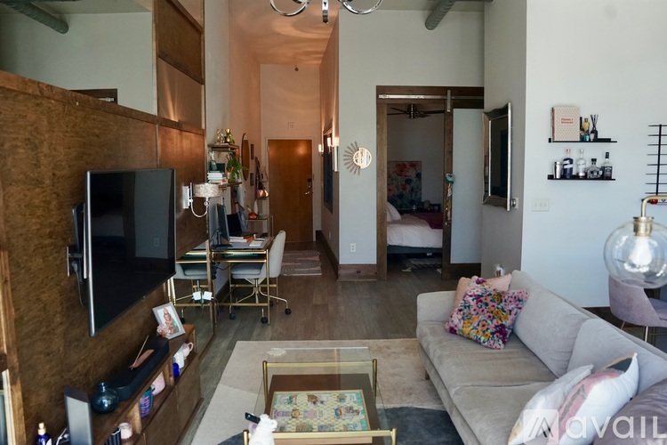 A living room with a grey couch and a wooden cabinet.