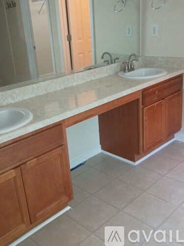 A bathroom with two sinks and wooden cabinets.