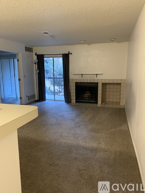 A living room with a fireplace and a sliding glass door.