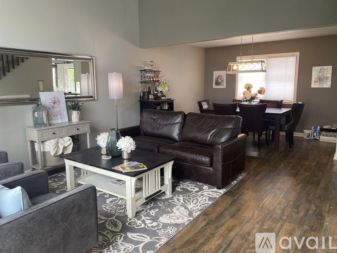 A living room with a grey couch, a coffee table, and a staircase.