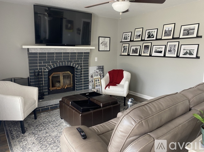 A living room with a fireplace, a chair, a couch, and a television.