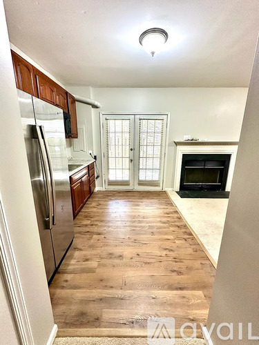 A kitchen with wooden floors and a refrigerator.