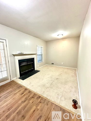 A room with a fireplace and wooden floors.