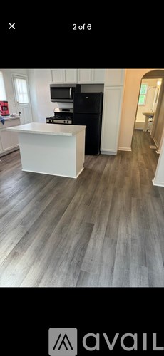 A kitchen with a black fridge and white countertop.