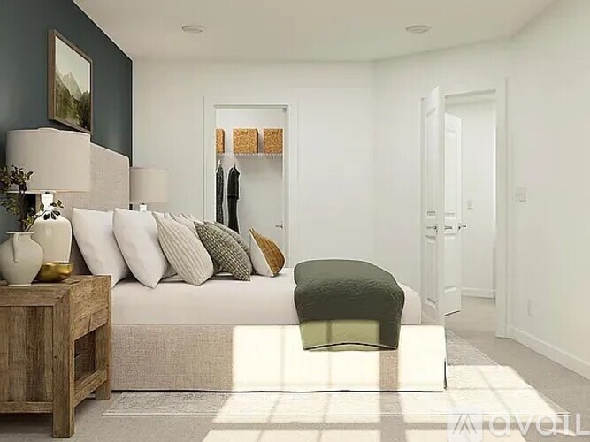 A modern bedroom with a large bed and a wooden side table.