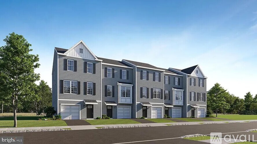 A modern two-story residential building with multiple garages.
