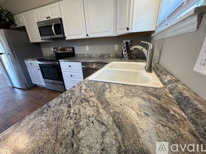 A kitchen with a granite countertop and white cabinets.