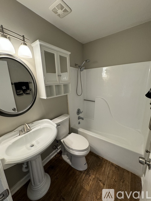 A bathroom with a toilet, sink, and mirror.
