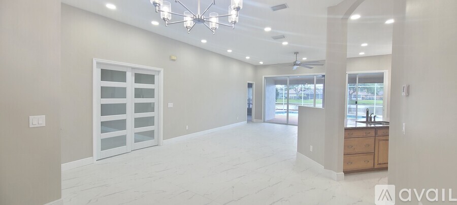 A spacious room with a chandelier and a large window.