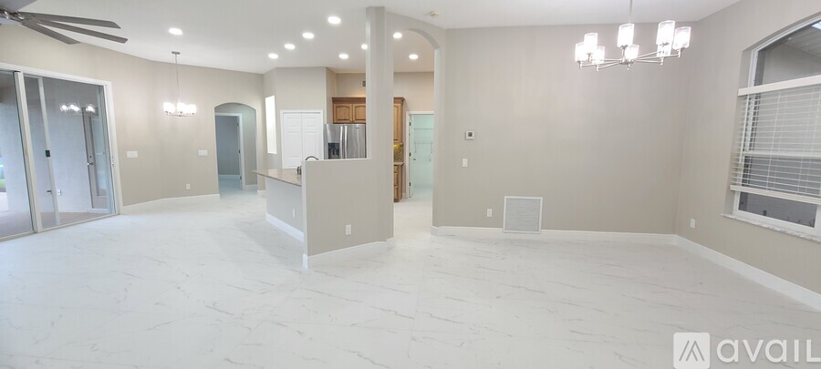 A spacious, empty room with a fan and a large window.