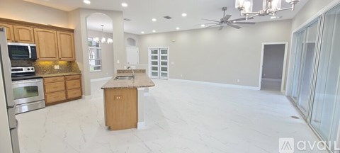 A kitchen with wooden cabinets and a marble countertop.