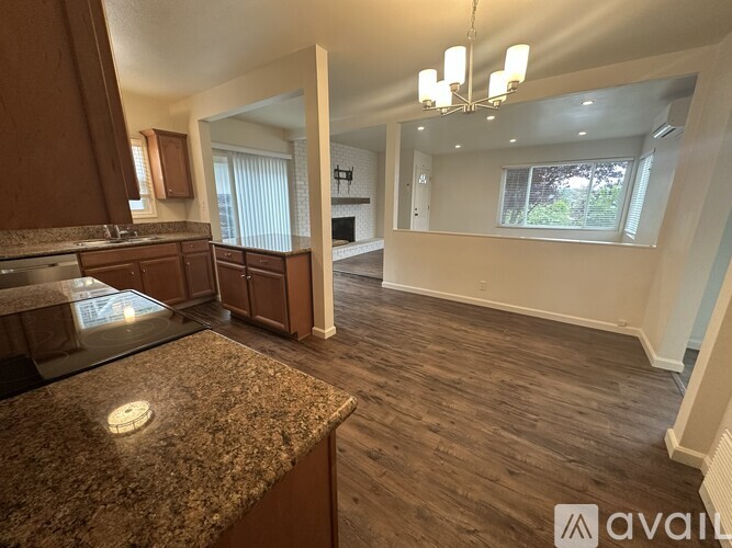 A kitchen with granite countertops and wooden floors.