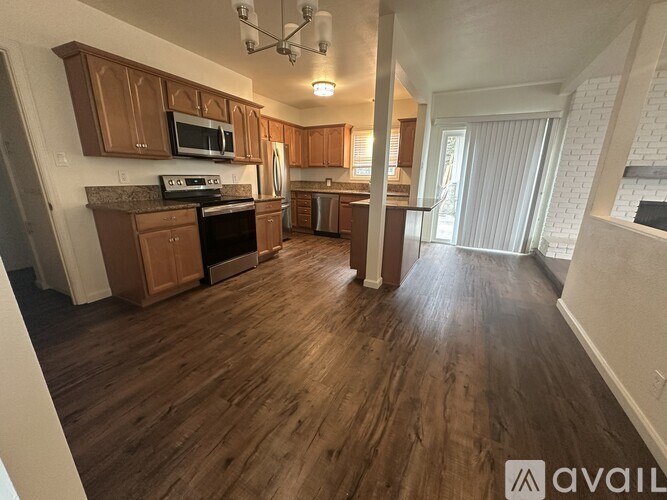 A kitchen with wooden floors and cabinets, a microwave, and a dishwasher.