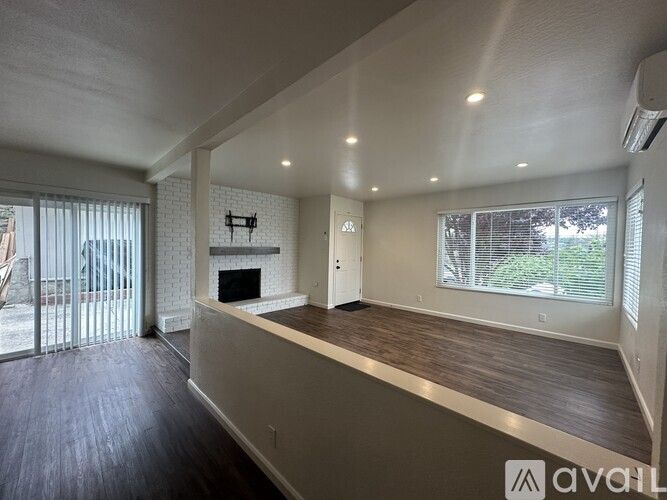 A spacious living room with a fireplace and sliding glass doors.