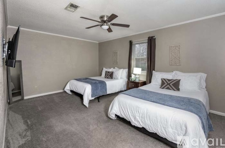 A bedroom with two beds and a ceiling fan.