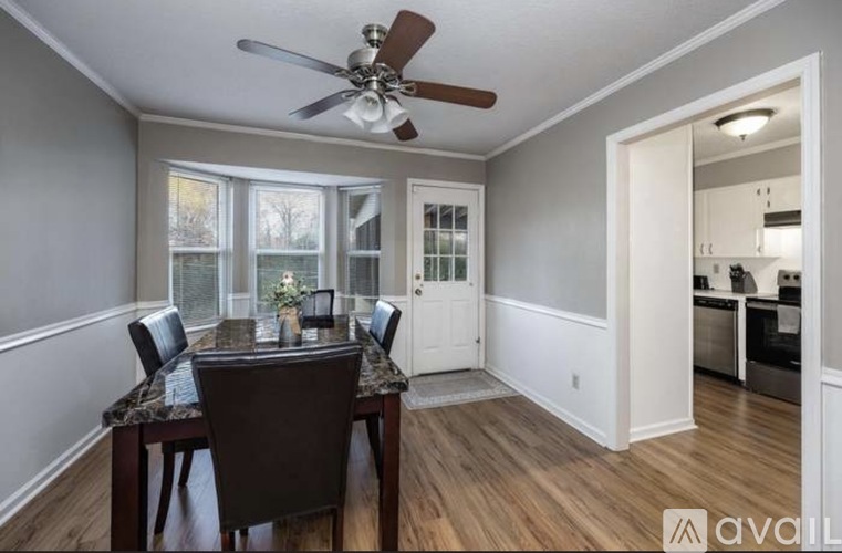 A dining room with a table and chairs and a ceiling fan.