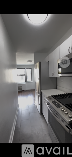 A kitchen with white cabinets and a stove top oven.