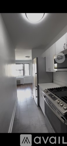 A kitchen with white cabinets and a stove top oven.