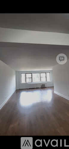 A room with wooden flooring and a window letting in light.
