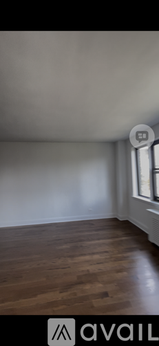 A room with wooden flooring and a window.