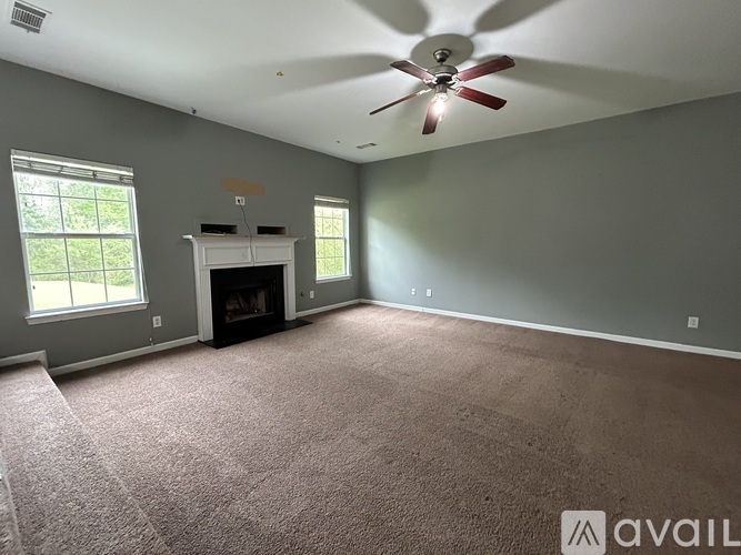 A room with a fireplace and a ceiling fan.