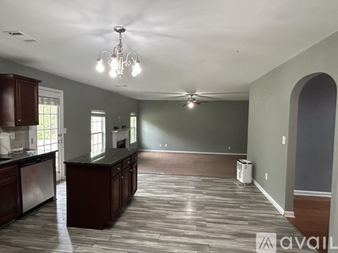 A kitchen with dark wood cabinets and a black countertop.