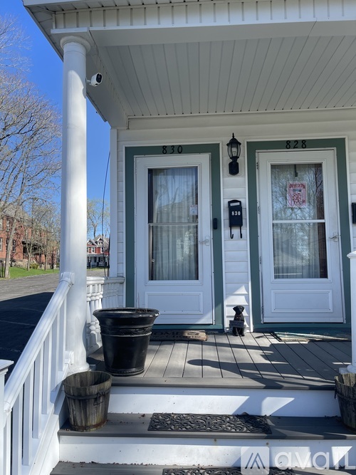 A white house with a porch and a mailbox on the front door.