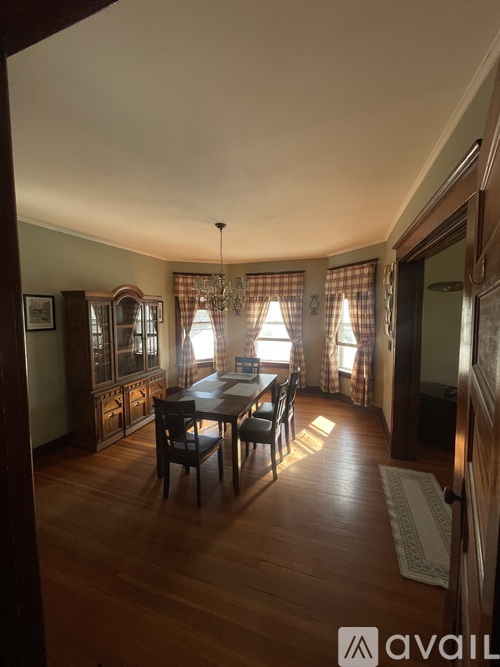 A dining room with a wooden table and chairs.