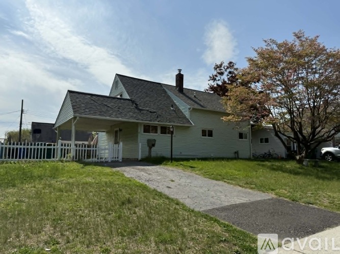 A house with a white picket fence and a grey roof.
