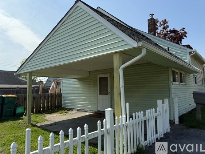 A small house with a white picket fence in front.