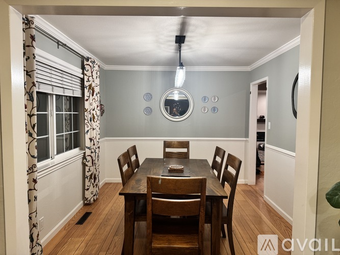 A dining room with a wooden table and chairs.
