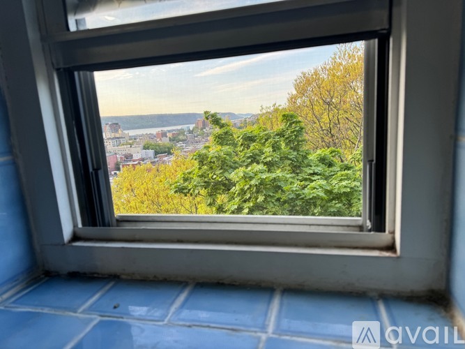 A window with a view of a cityscape and trees.